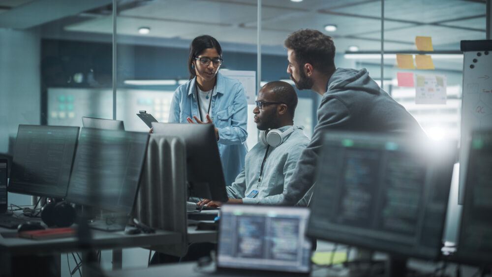 Diverse Group of Professionals Meeting in Modern Office: IT Programmers Use Computer, Talk Strategy, Discuss Planning and security