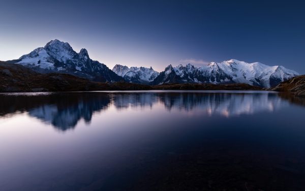 Mount Mont Blanc covered in the snow reflecting on the water in the evening in Chamonix, France