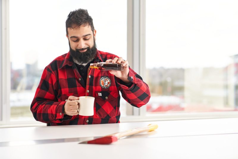 Lumberjack enjoys glass of maple syrup
