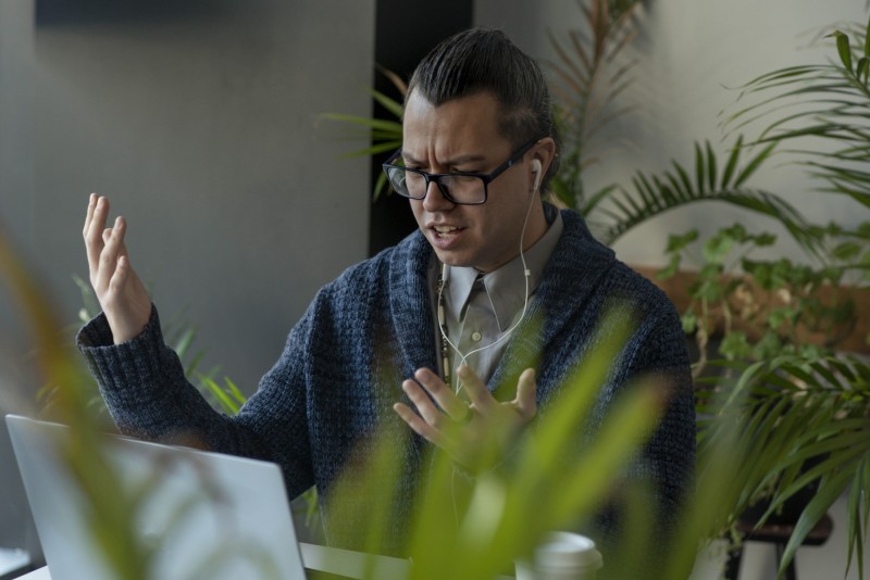 Man frustrated on a video chat while having coffee at café