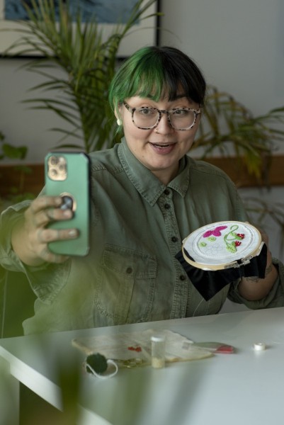 Woman posting a video on social media showing her beadwork