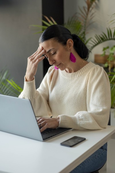 Woman frustrated while working on laptop at a café